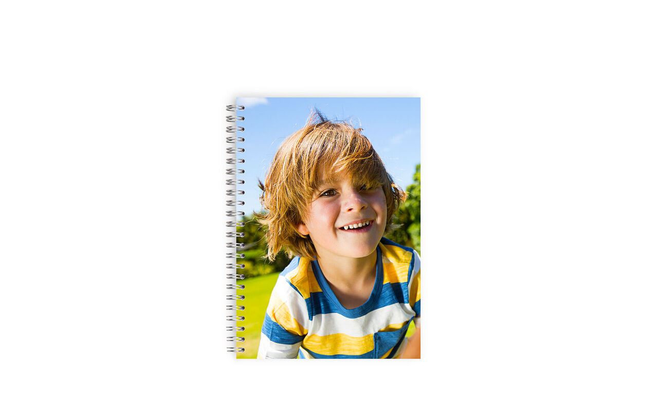 Fröhliches Kind mit einem persönlichen Notizbuch in der Hand, umgeben von Natur.