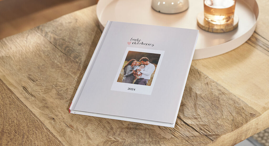 Helles Fotobuch auf einem Tisch mit einem Familienfoto auf dem Cover