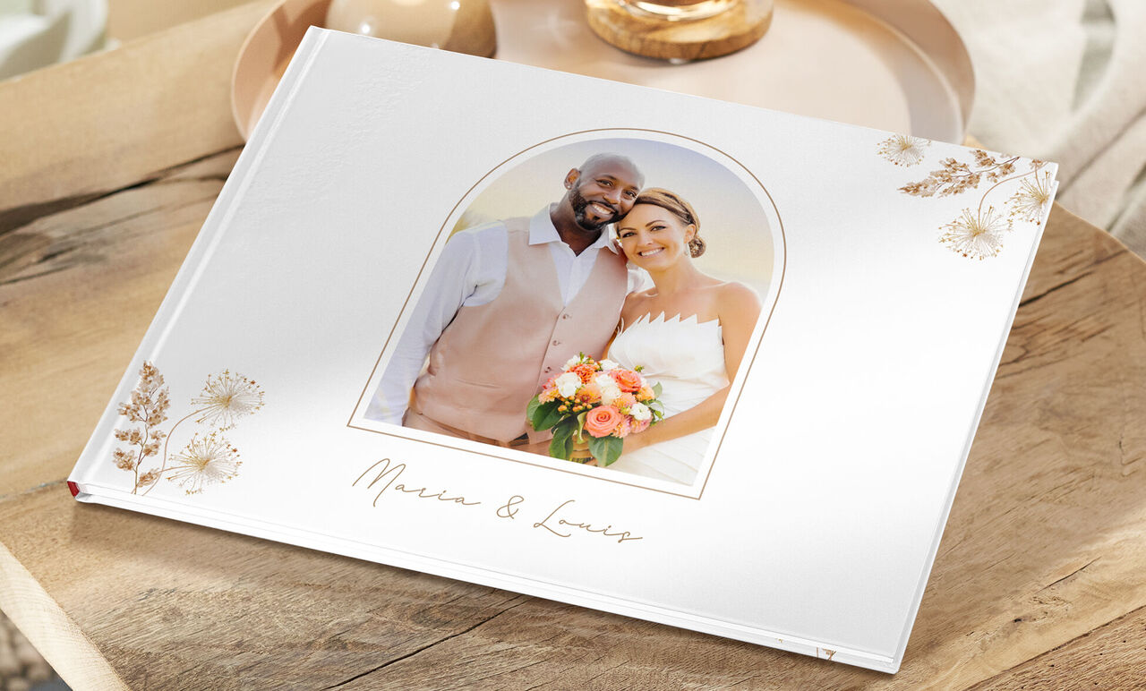 CEWE FOTOBUCH Hochzeit mit Foto des Brautpaars und Blumenverzierung auf weißem Cover