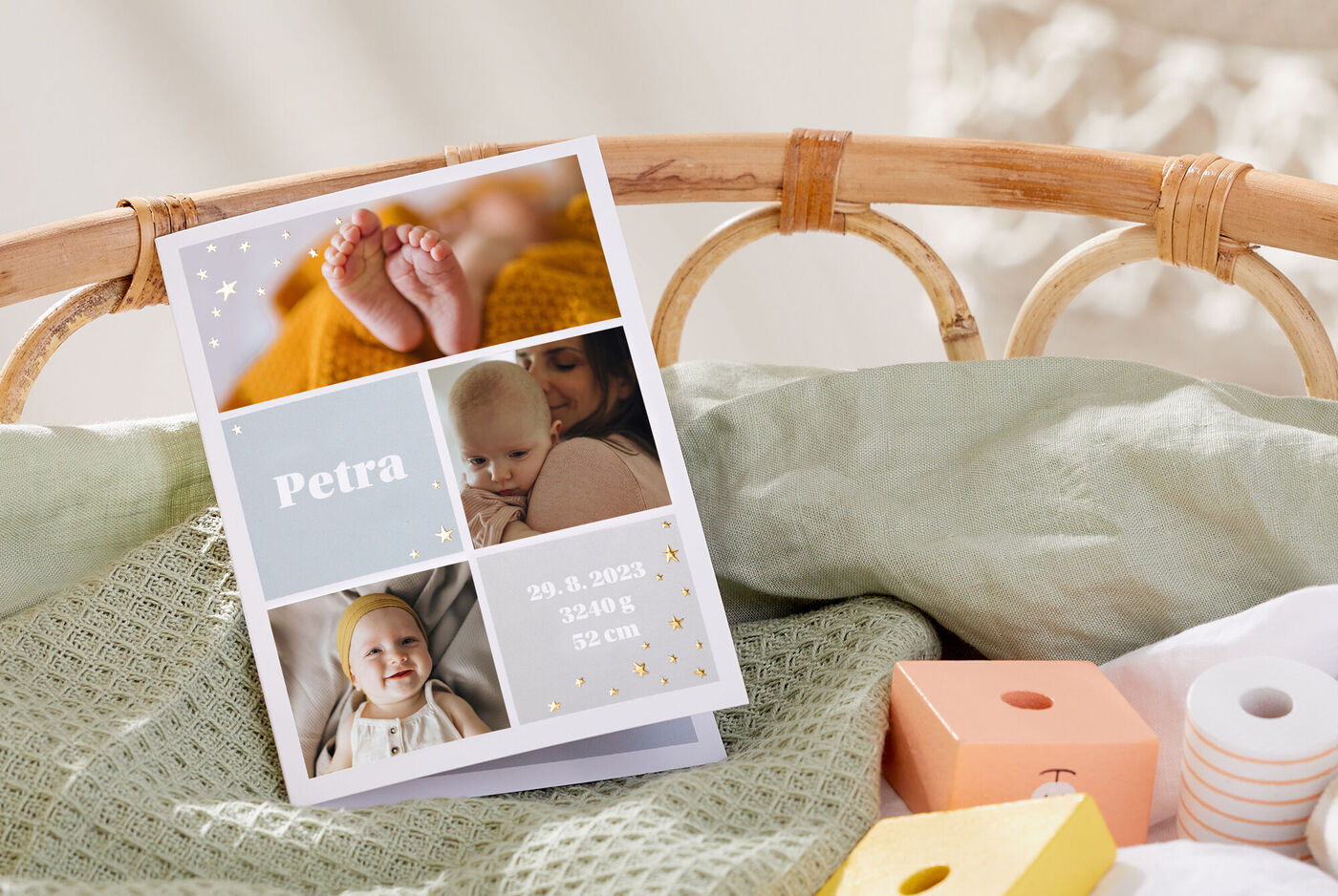 Eine liebevoll gestaltete Grußkarte mit einem Namen und Fotos von Babyfüßen und -kleidung auf einem weichen Untergrund