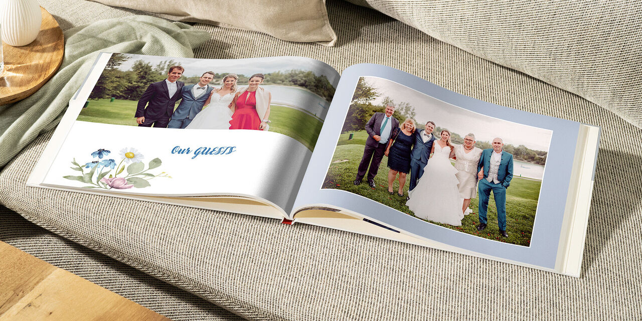 Ein CEWE Fotobuch auf einem gemütlichen Sofa, das schöne Hochzeitsmomente zeigt.