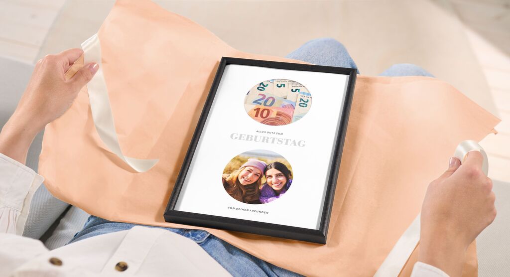Eine Person hält ein schön verpacktes Geschenk mit einem gerahmten Bild auf dem Schoß. Es zeigt die Freude über ein besonderes Ereignis.