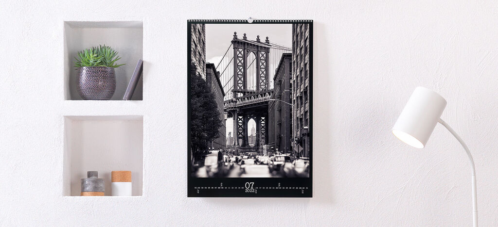 Wandkalender mit Fotografie der Brooklyn Bridge in Schwarz-Weiß, an einer hellen Wand.