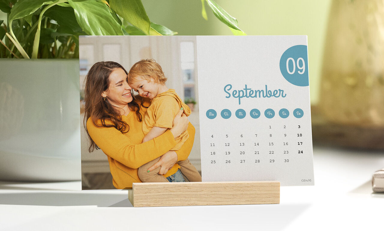 Ein liebevoll gestalteter Kalender mit dem Monat September und einem Bild von einer Mutter, die ihr Kind in den Armen hält.