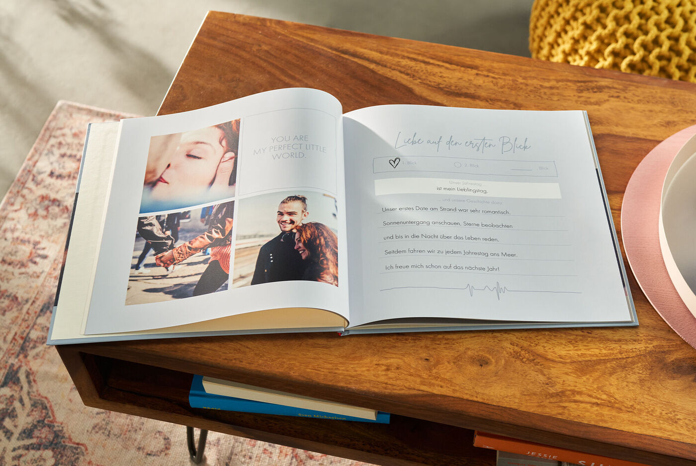 Offenes CEWE FOTOBUCH auf einem Tisch, zeigt Fotos von glücklichen Momenten und Platz für handschriftliche Notizen