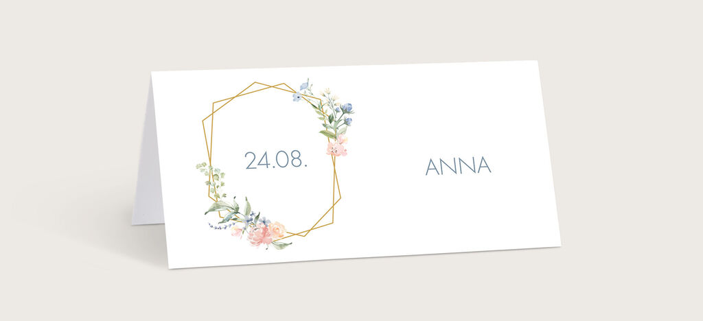 Ein Platzkarten-Design für eine Hochzeit mit einem Blumenmotiv und goldenen Details