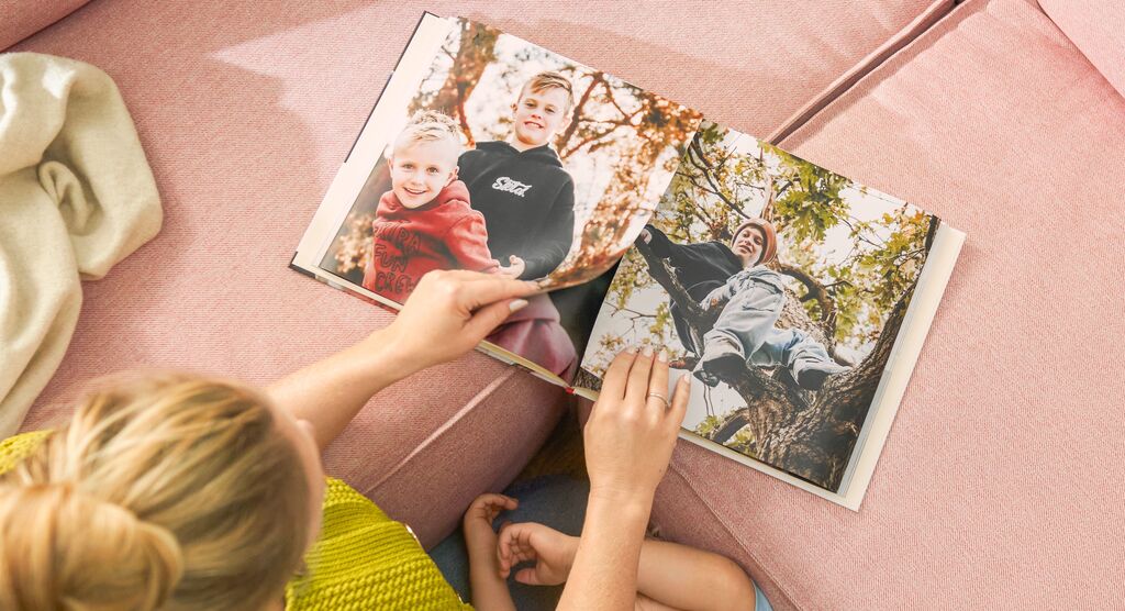 Eine Person blättert durch ein Fotobuch mit Erinnerungen an einen Tag im Freien.