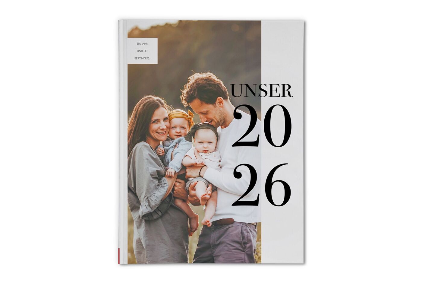 CEWE FOTOBUCH mit Motiv einer Familie, Eltern halten gemeinsam zwei kleine Kinder im Arm, daneben steht der Text Unser 2025
