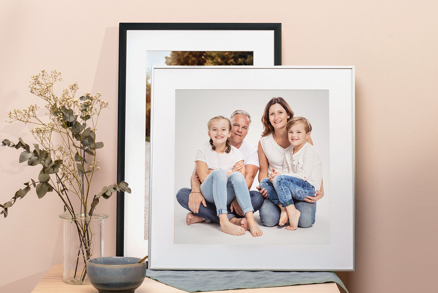 Eine liebevolle Familienaufnahme in einem schönen Rahmen, umgeben von Blumen und einer Dekoschale.