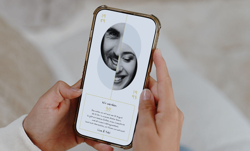 Ein Smartphone wird in den Händen gehalten, auf dem Bildschirm ist die digitale Grußkarte im Partner-Design zu sehen.