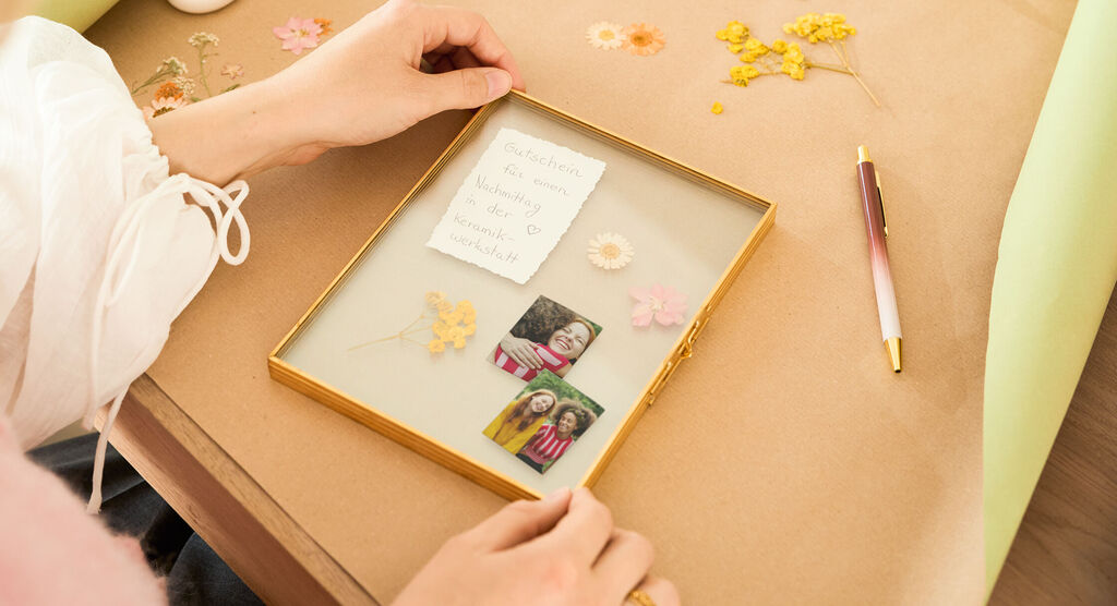 Eine liebevoll gestaltete Bilderrahmen-Dekoration mit Trockenblumen und Erinnerungsfotos