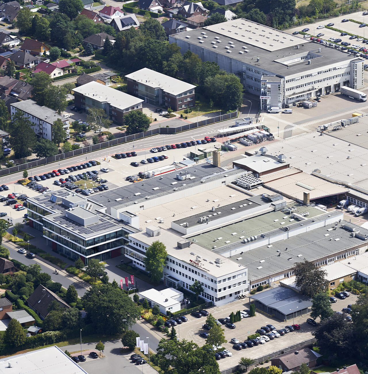 Luftaufnahme des Unternehmensgeländes mit modernen Gebäuden und Parkplätzen