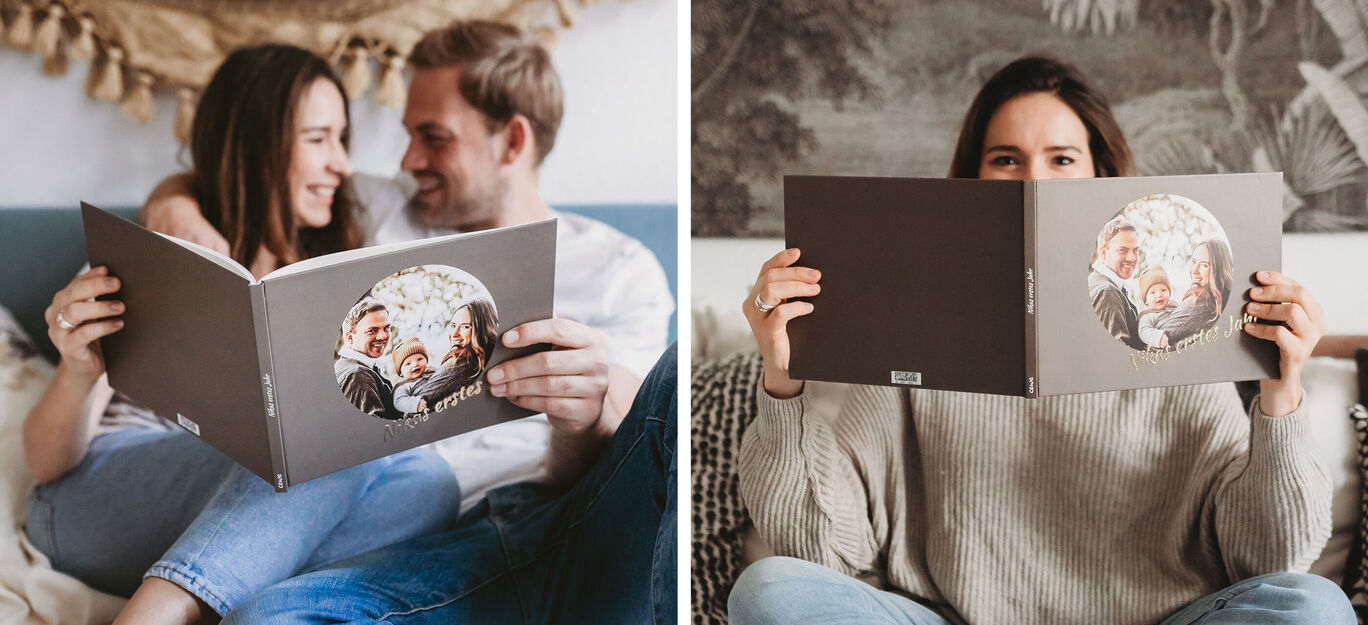 Ein Paar schaut glücklich in ein Fotobuch mit Familienfotos.