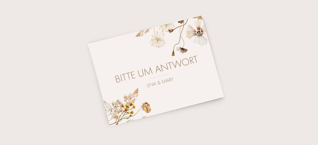 Ein elegantes Einladungskärtchen mit einem floralen Design in sanften Farben, auf dem "Bitte um Antwort" sowie die Namen "Una & Mary" geschrieben stehen