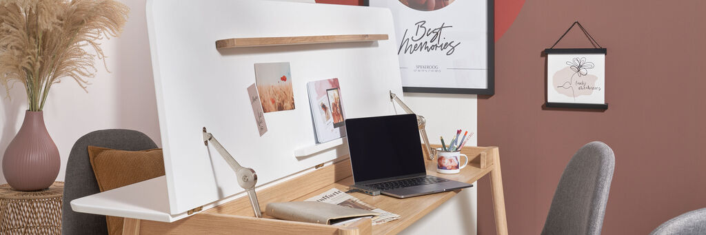 Ein liebevoll gestalteter Schreibtisch mit Laptop, Notizen und Bildern