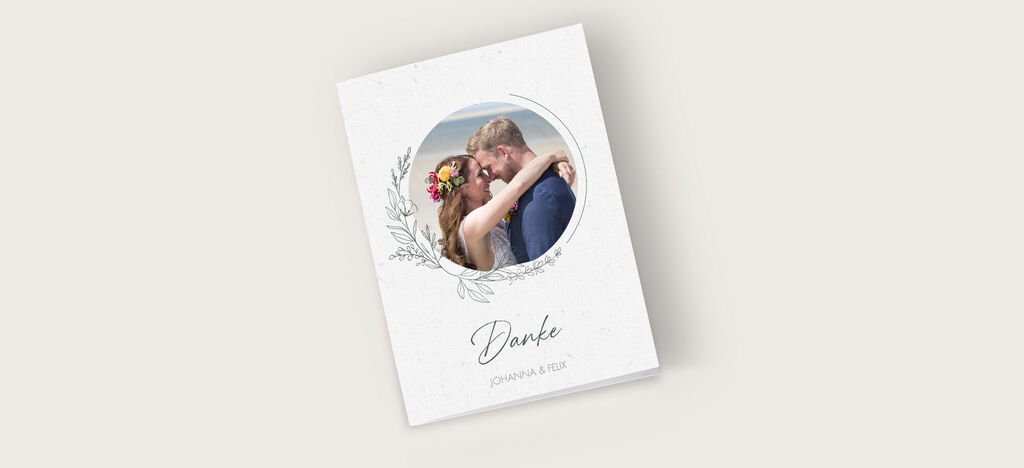 Eine romantische Dankeskarte mit einem ovalen Bildausschnitt eines Paares am Strand. Ölgemälde-ähnlicher Hintergrund mit floralen Elementen.