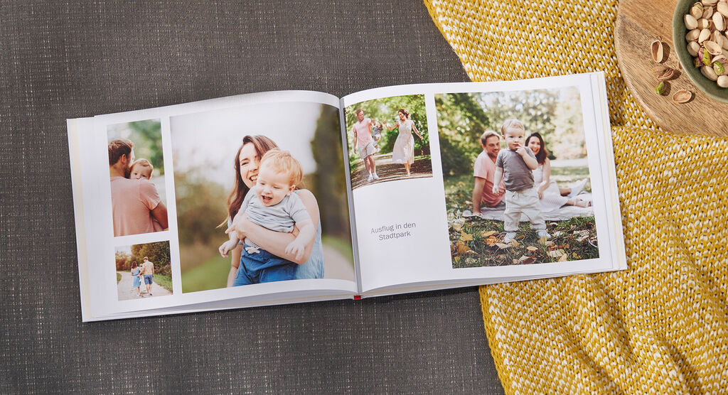Ein geöffnetes CEWE Fotobuch mit Erinnerungen an fröhliche Momente im Freien