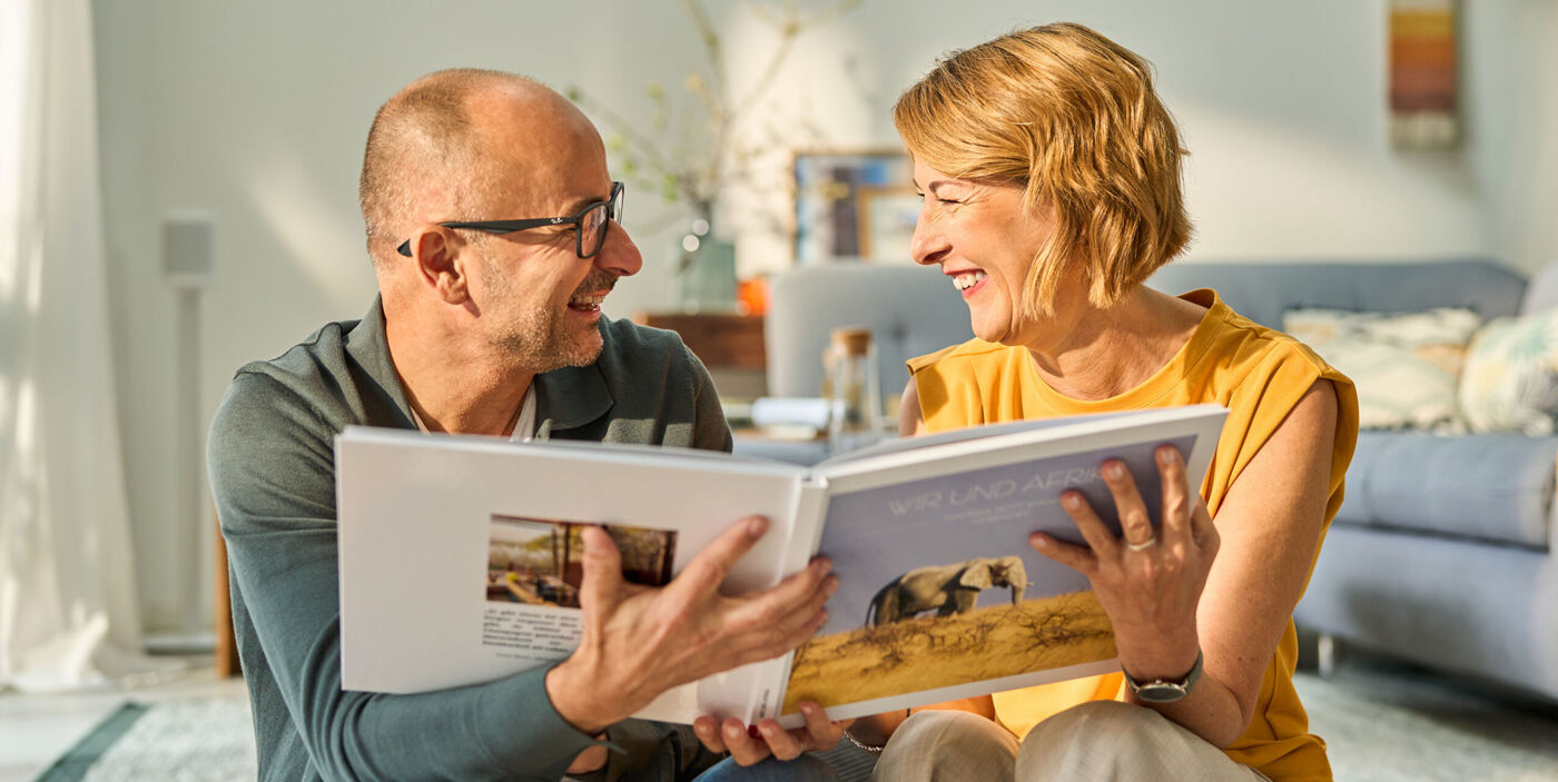 Ein Mann und eine Frau schauen zusammen in ein Fotobuch