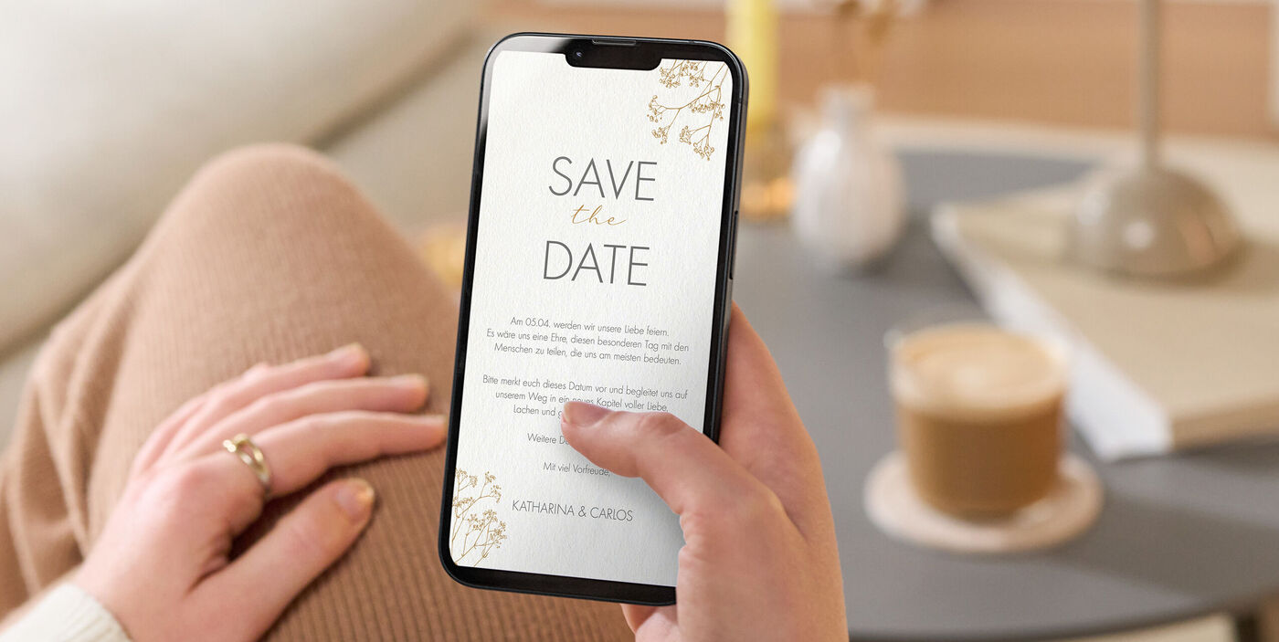 Eine digitale Safe the Date Karte in gold-weißem Design ohne Foto auf einem Handybildschirm.