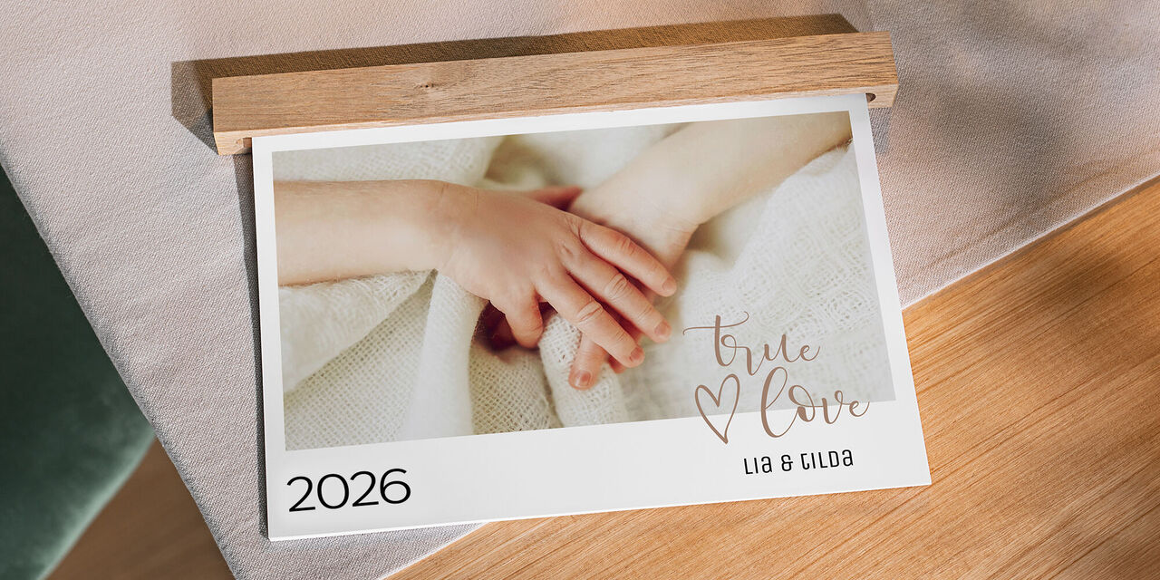 Zwei Hände mit einem besonderen Band, sanft auf einem Tisch, drücken Liebe aus, für den CEWE Fotokalender 2024.