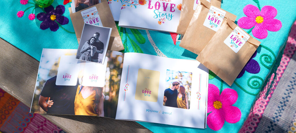 Bunte Gestaltung eines CEWE FOTOBUCHS mit dem Titel 'Love Story', umgeben von mehreren kleinen Päckchen.