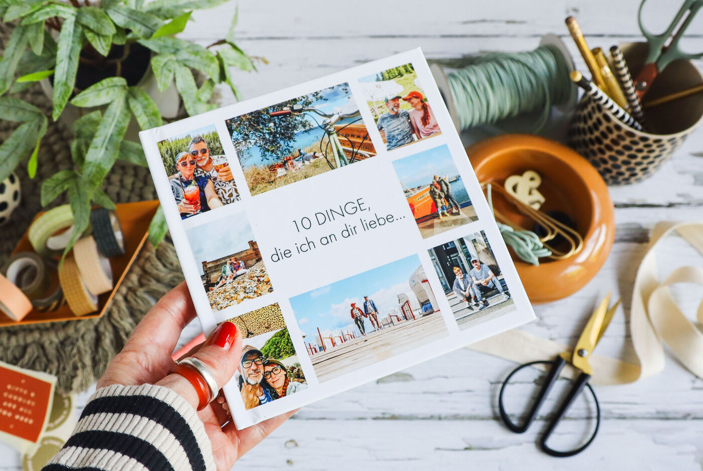 Ein liebevoll gestaltetes Fotobuch mit Collage aus Familienfotos, umgeben von Bastelmaterialien.