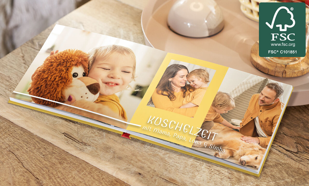 Offenes CEWE FOTOBUCH mit Kinderfotos und Kuschelzeit mit Familie