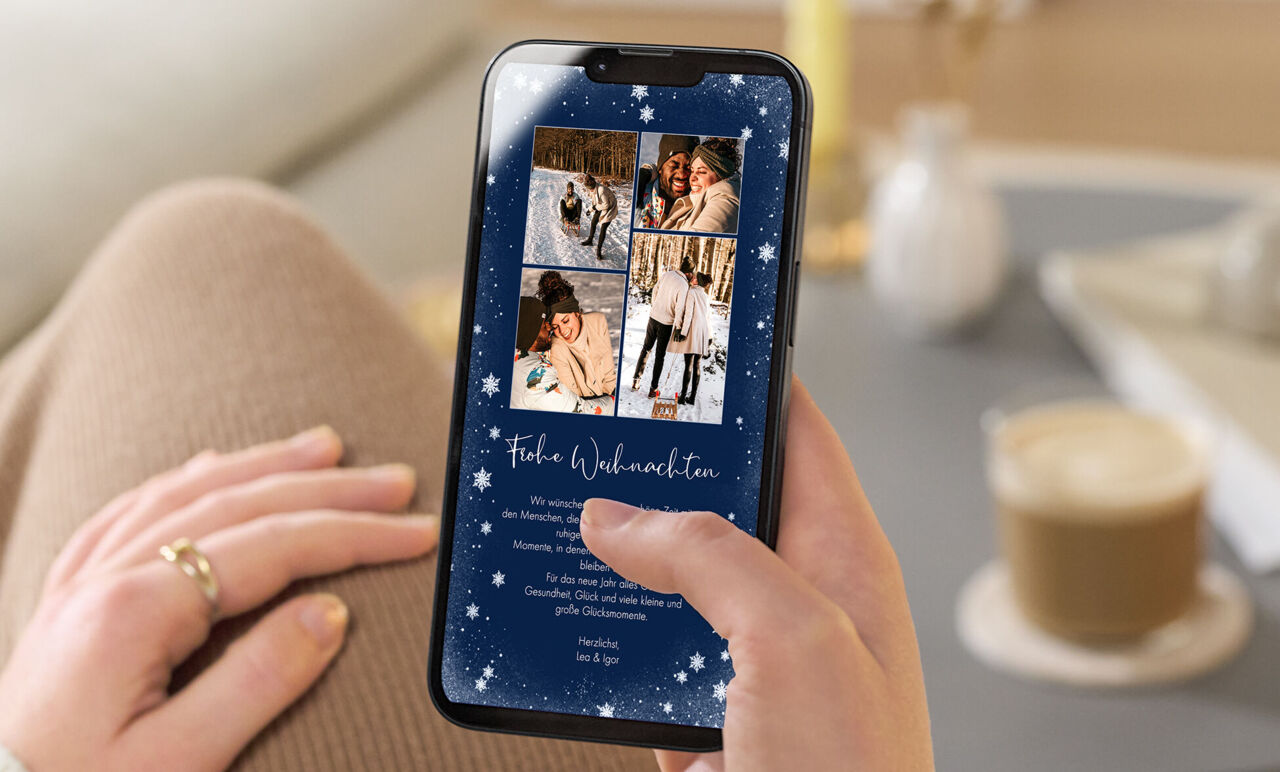 Eine digitale Weihnachtskarte in einem dunkelblauen Design mit Schneeflocken und einem großen zentral oben platzierten Foto