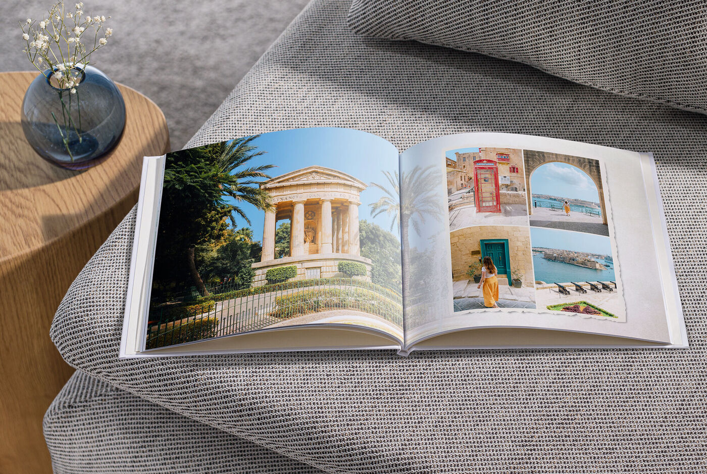 Offenes Fotobuch auf einem Tisch mit Urlaubserinnerungen.
