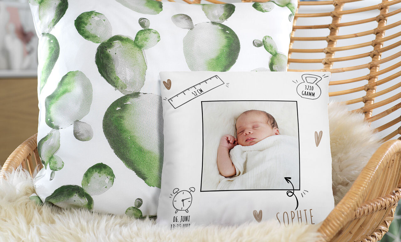 Gemütliche Wohnatmosphäre mit Kissen und einem personalisierten Kissen mit einem Baby-Motiv.