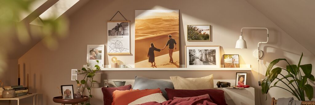 Ein gemütliches Schlafzimmer mit dekorativen Fotos und einem großen Wandbild einer Person mit einem anderen im Sand.
