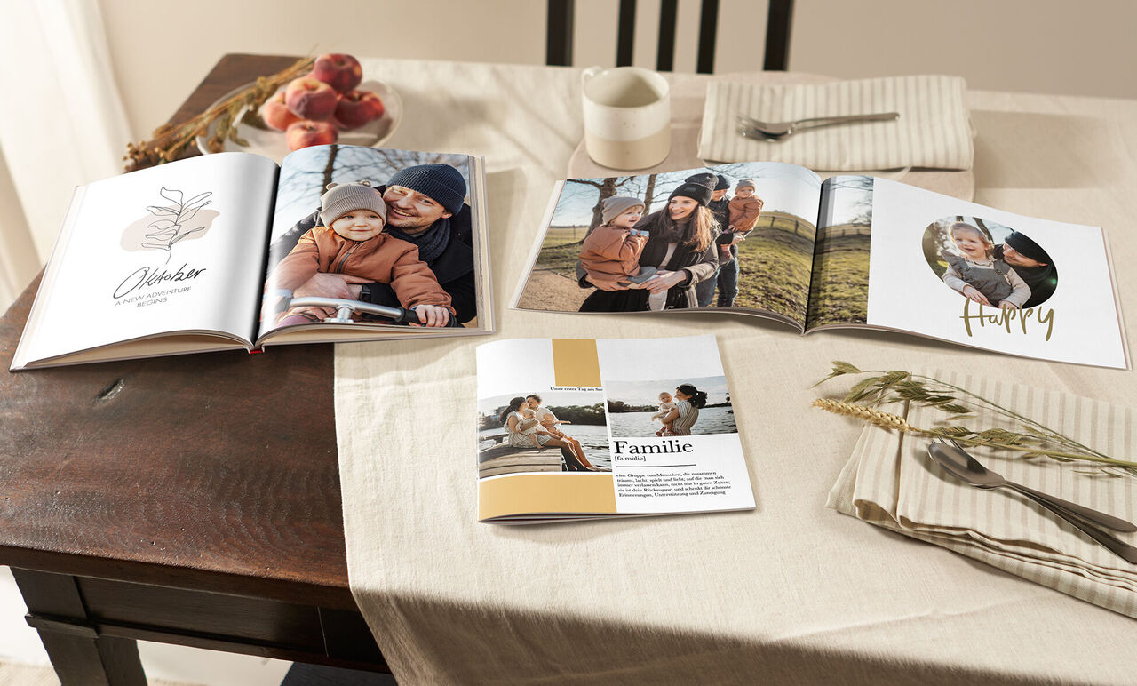 Ein liebevoll gestaltetes Fotobuch auf einem Tisch. Es zeigt Familienmomente und Glücksmomente.