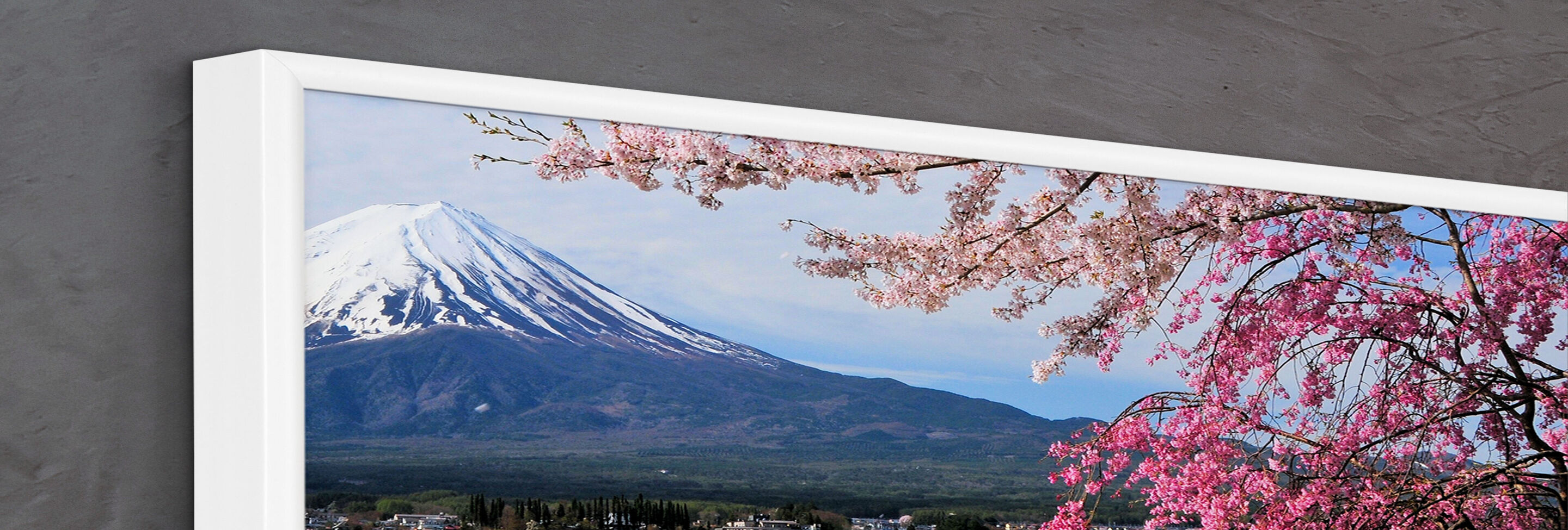 Weiß gerahmtes CEWE Wandbild mit Berg und rosa Blüten