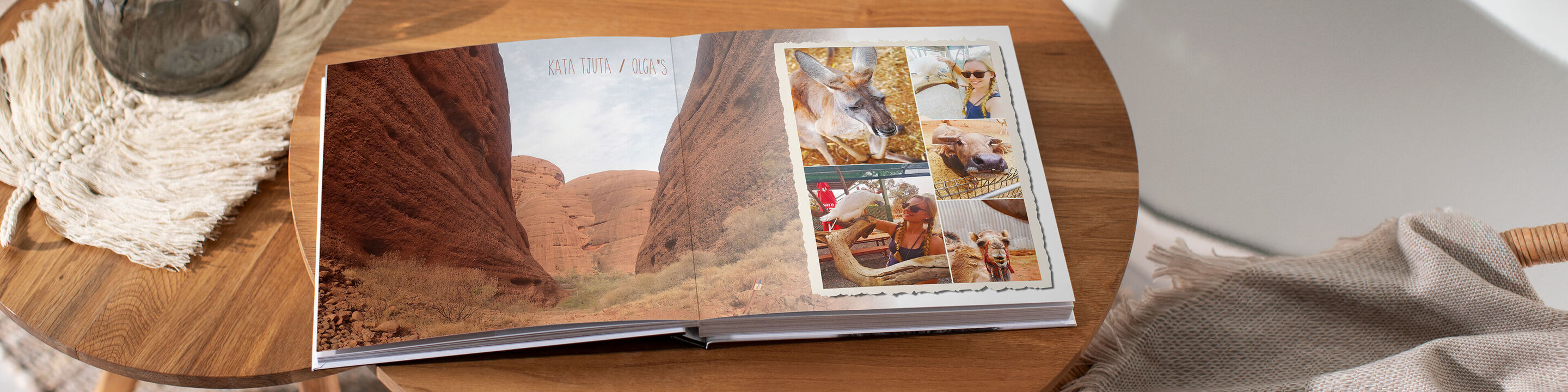 Offenes Fotobuch mit Bildern von einer Landschaft und Erinnerungen am Tisch
