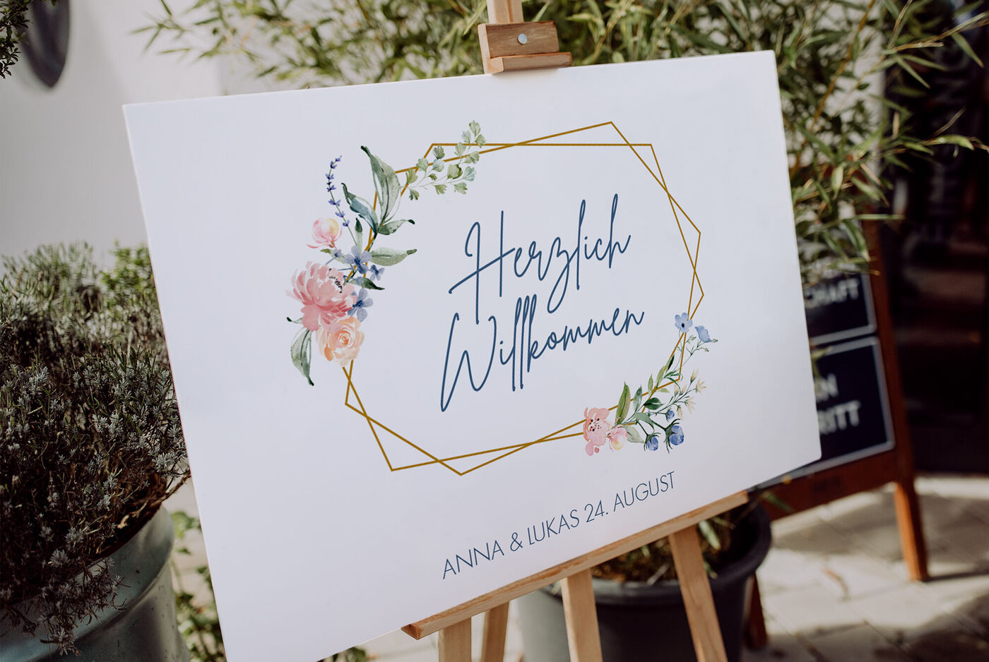 Willkommensschild mit floralem Design und goldener Umrandung