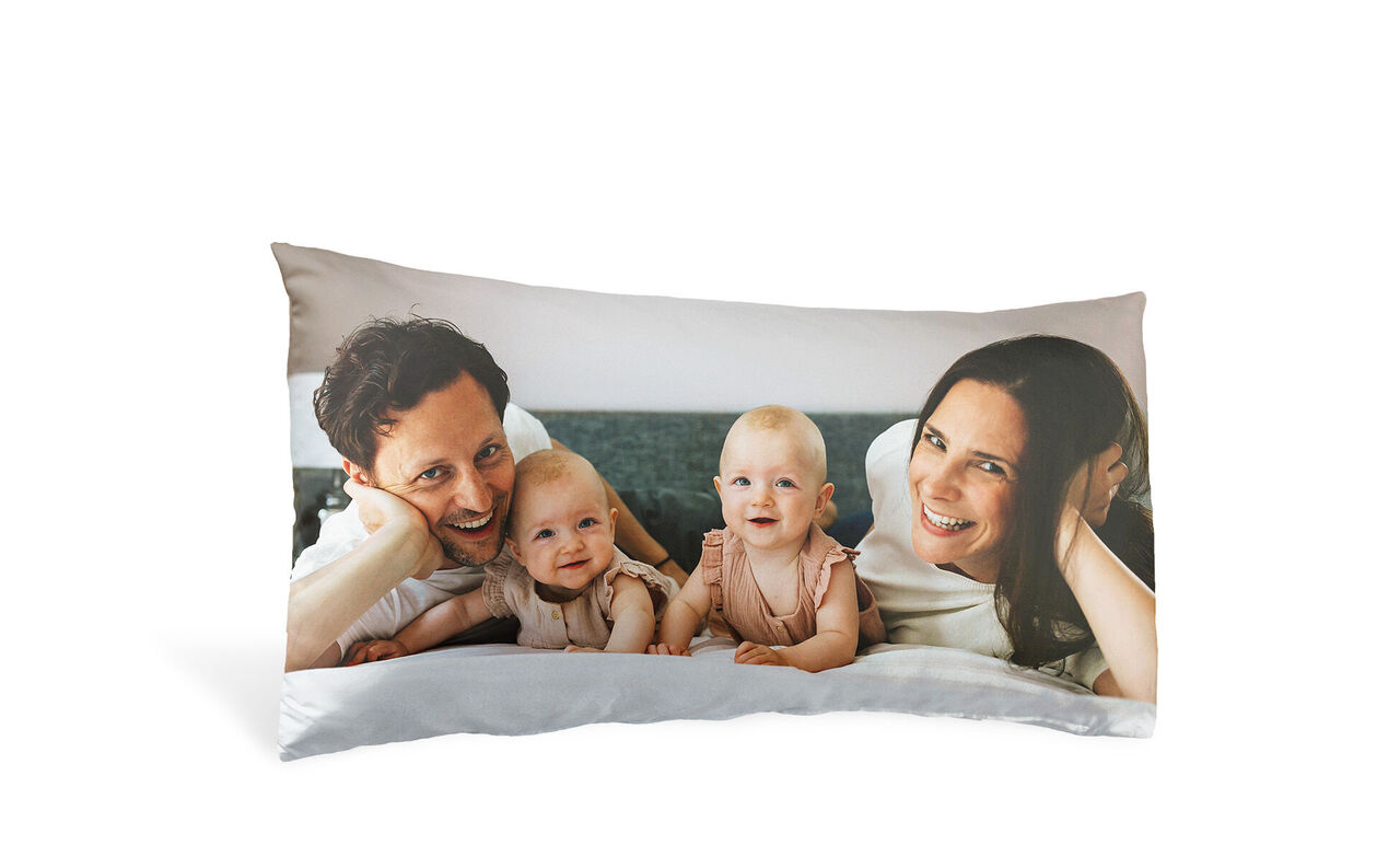 Süßes Familienfoto auf einem Kissen mit zwei kleinen Kindern und Eltern.