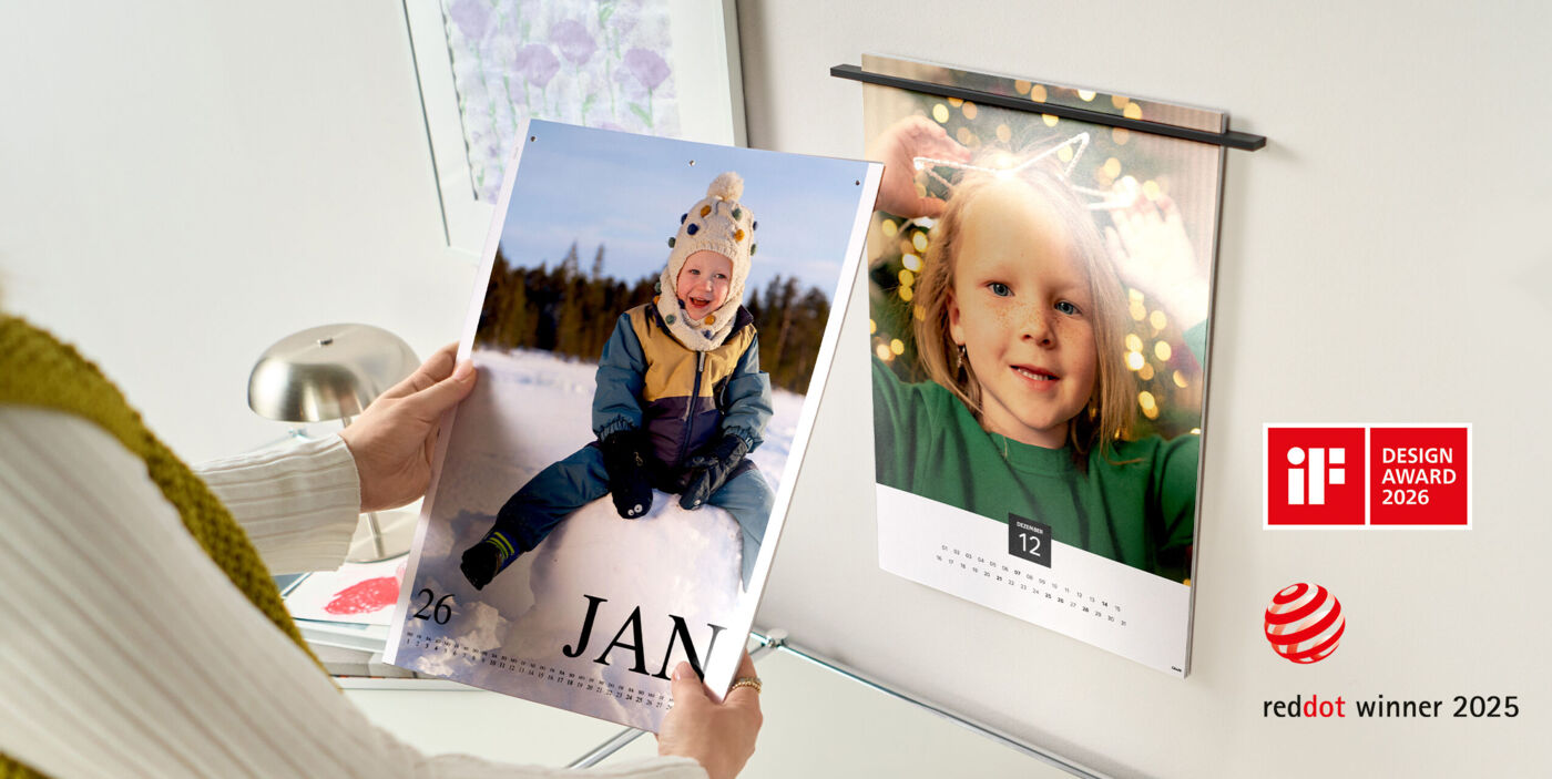 Zwei aufgehängte Kalenderseiten mit Familienfotos, eine Seite zeigt ein Kind im Schnee, CEWE Fotokalender