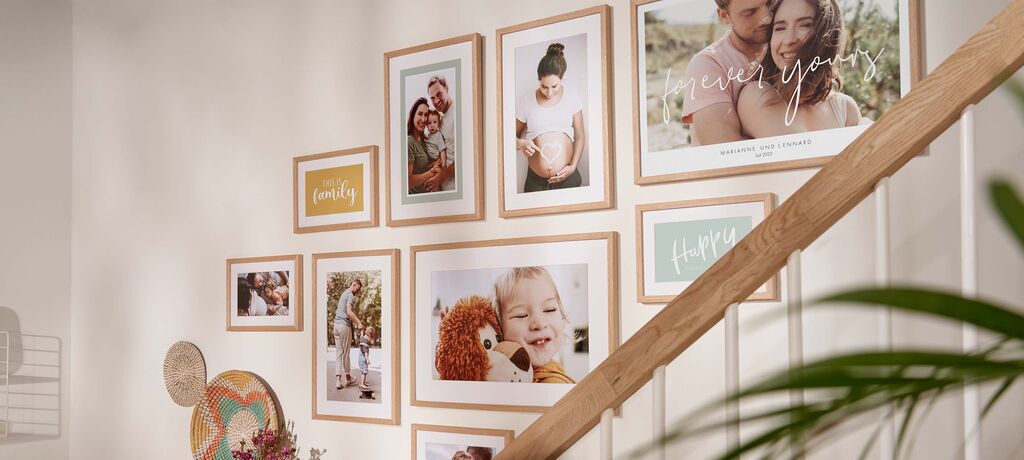 Wand mit verschiedenen gerahmten Fotos und einer Leuchte