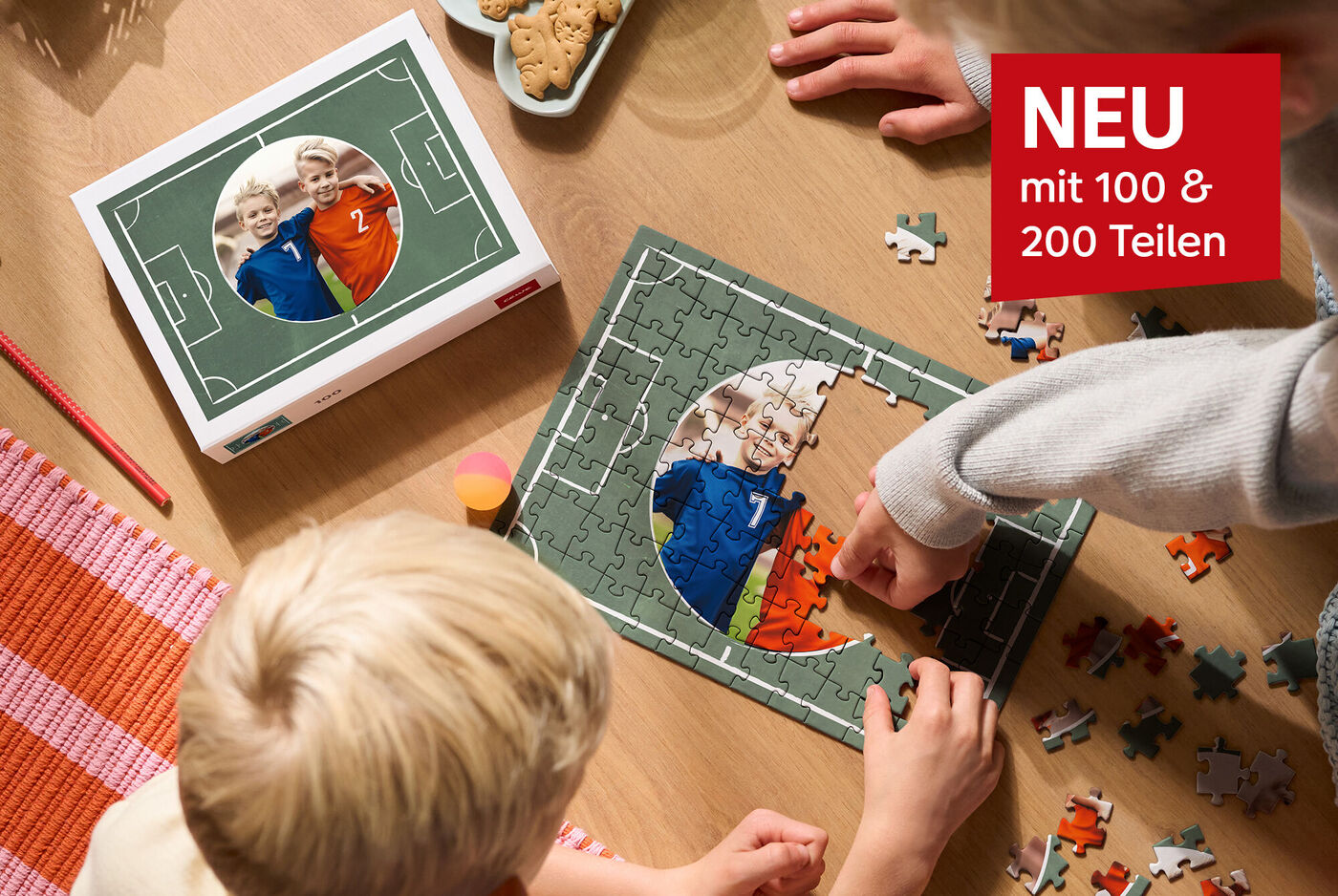 Kinder legen gemeinsam ein Fußball-Puzzle und lachen fröhlich