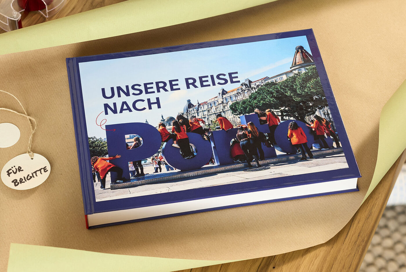 Geschlossenes CEWE FOTOBUCH mit dem Titel "Unsere Reise nach Porto" auf Geschenkpapier