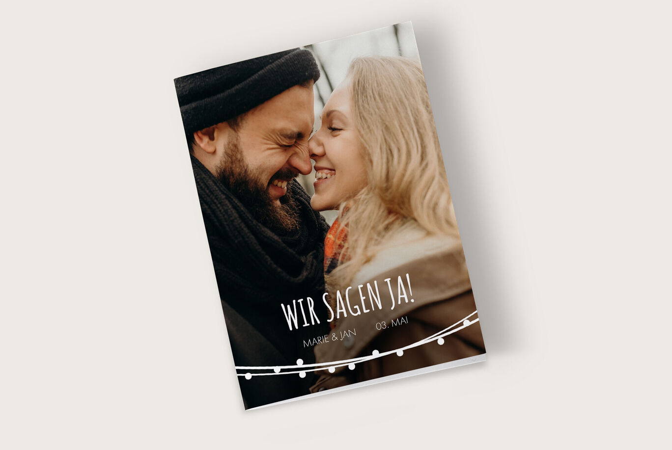 Hochzeitsanzeige mit romantischem Paar und Einladungstext.