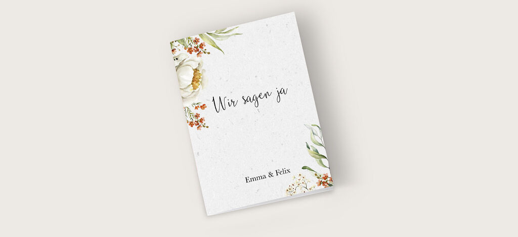 Ein liebevoll gestaltetes Hochzeitsalbum mit dem Titel "Wir sagen ja" und floralen Elementen in sanften Farben.