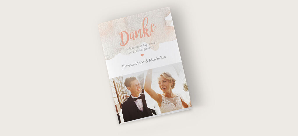 Hochzeitskarte mit der Aufschrift 'Danke' in eleganten Schriftzügen und rosa Akzenten.