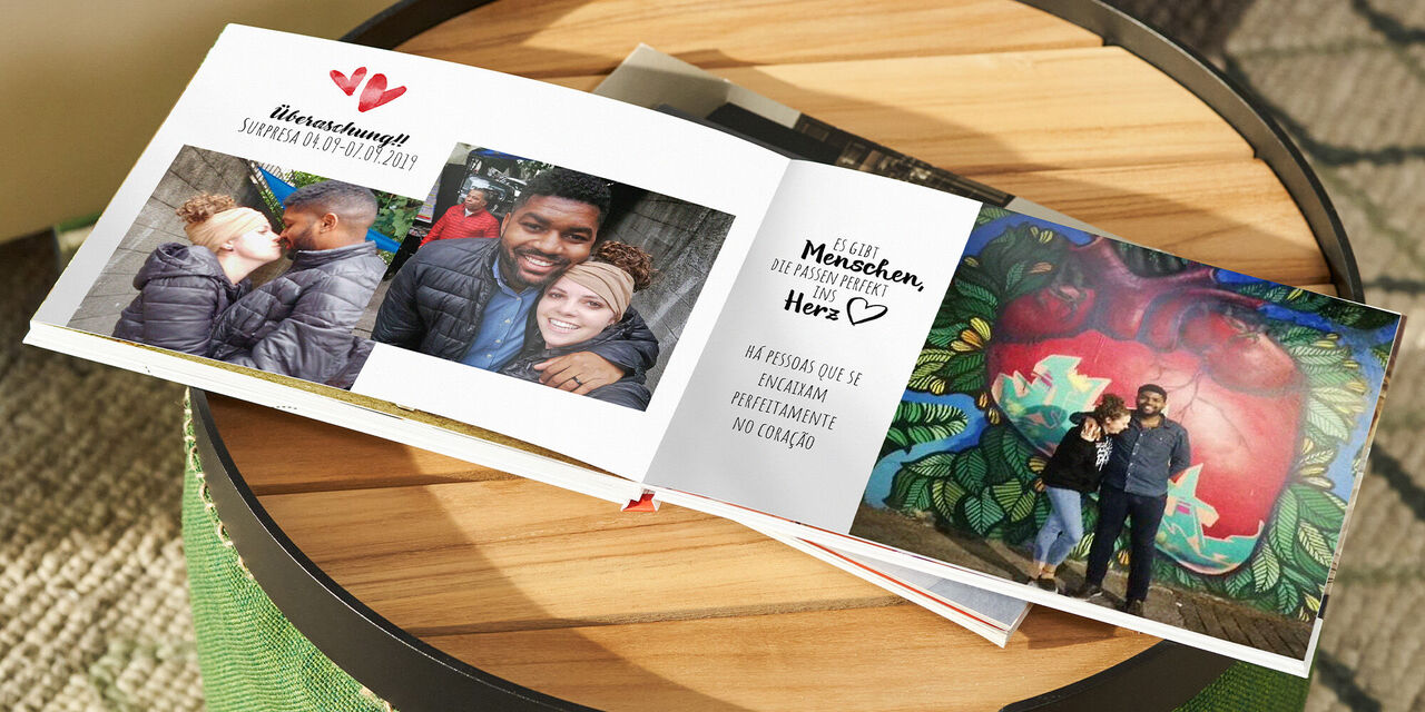 Ein offen liegendes Fotobuch mit Erinnerungen an besondere Momente, zusammen mit kreativen Gestaltungselementen
