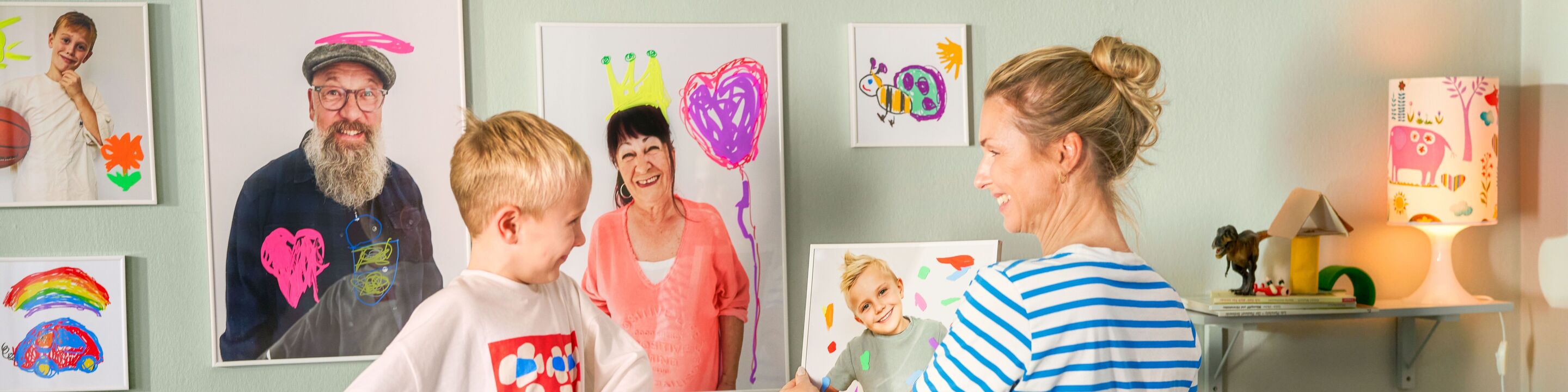 Kind und Erwachsene gestalten liebevoll bemalte Poster und Bilderrahmen in einem kreativ eingerichteten Raum