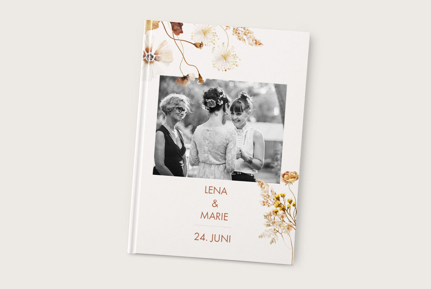 Drei Frauen in eleganter Kleidung stehen zusammen vor einem Fotobuch mit Blumenmotiv