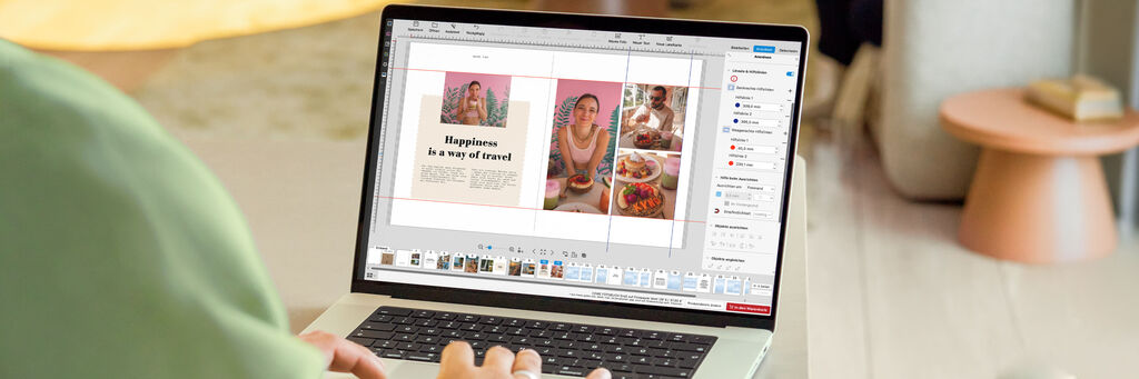 Eine Person arbeitet an einem Laptop. Auf dem Bildschirm ist eine Fotobuch-Seite mit eingeschalteten Hilfslinien zu sehen.