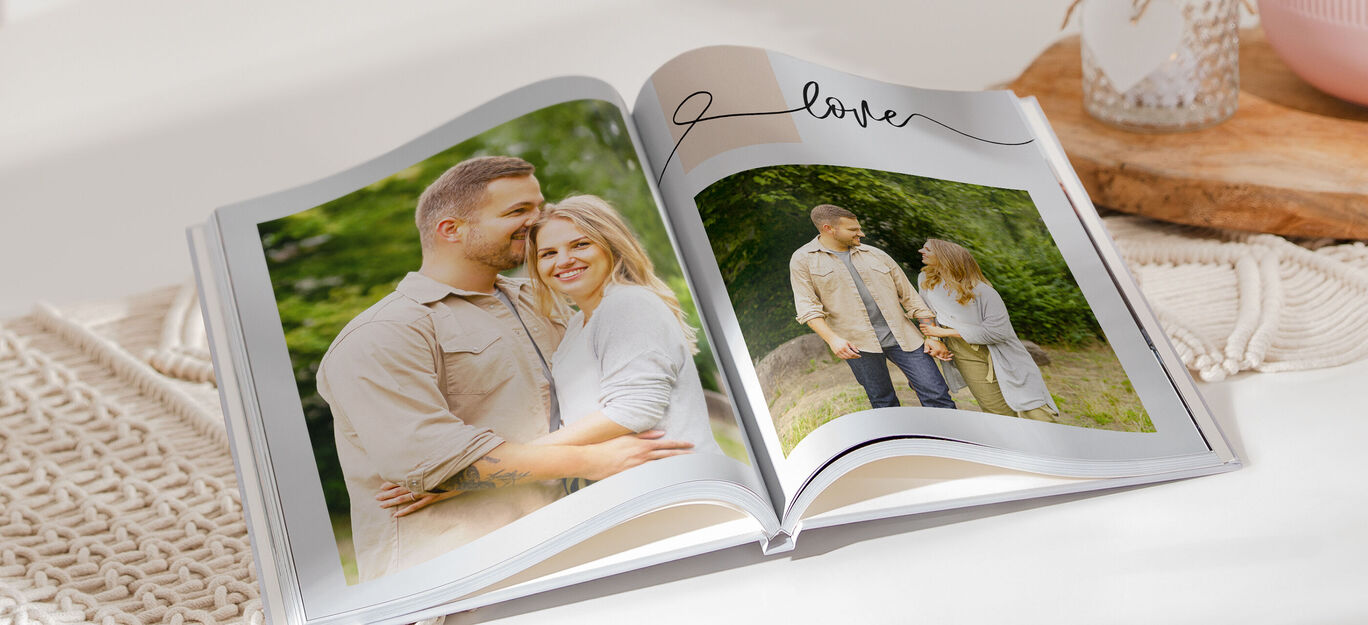 Ein geöffnetes Fotobuch zeigt glückliche Momente eines Paares und eines Kindes im Freien. Liebevolle Erinnerungen werden geteilt.
