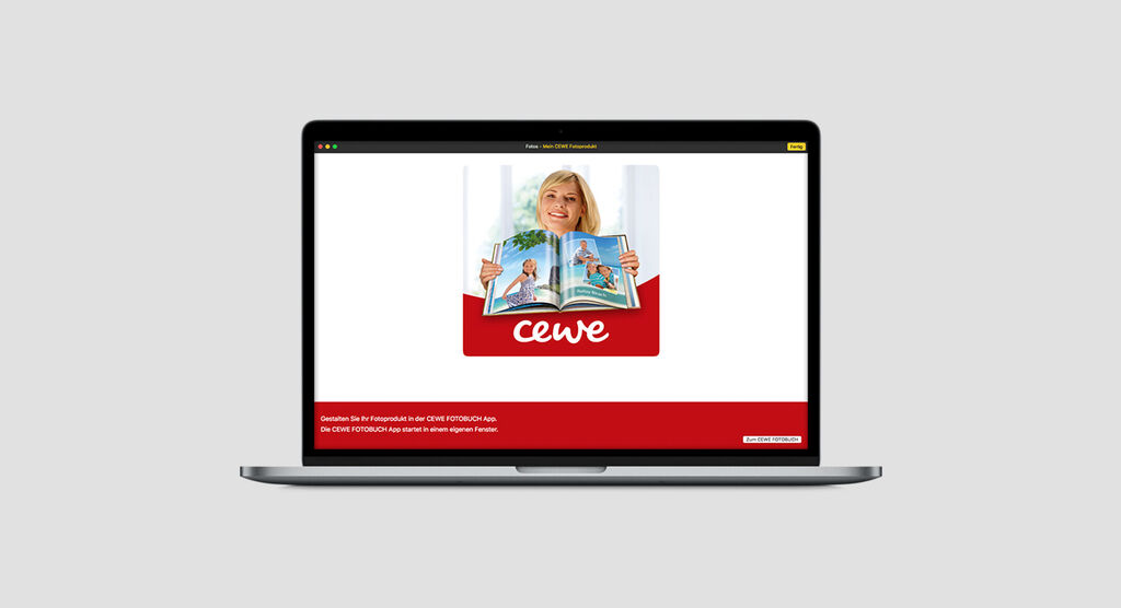 Eine Person blättert in einem CEWE FOTOBUCH auf einem Laptop.