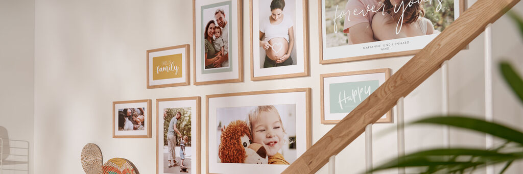 Wand mit gerahmten Familienfotos und Erinnerungen in warmen Farben